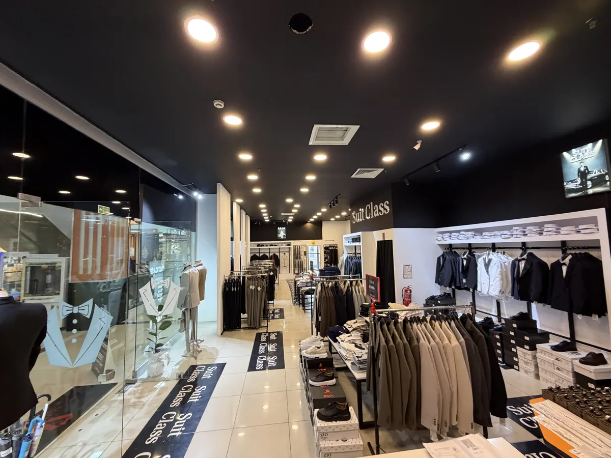 SUIT CLASS mağaza içi: askıda ceketler, vitrin ve marka zemini